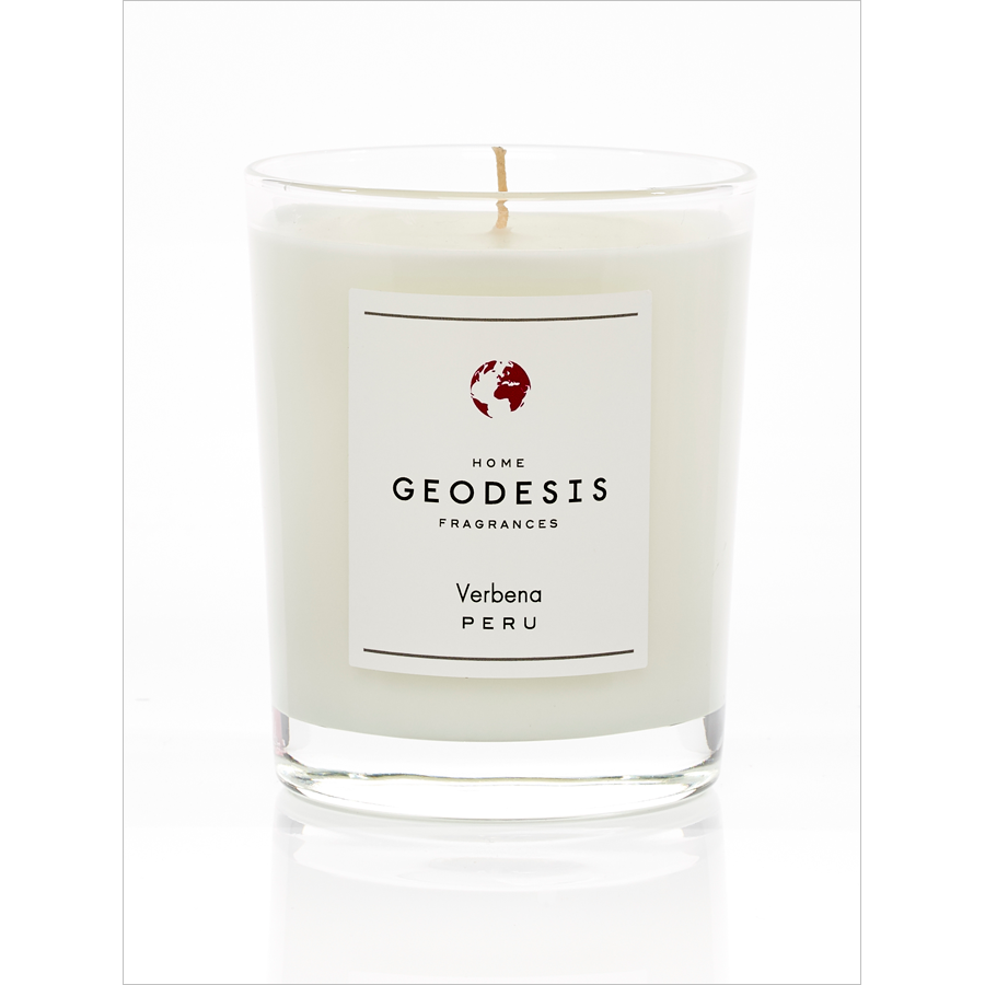 A Geodesis Verveine 180gm scented candle in a clear glass jar with a white label featuring the text "Peru with Verbena" below an emblem of a globe. The candle has a single, unlit wick.