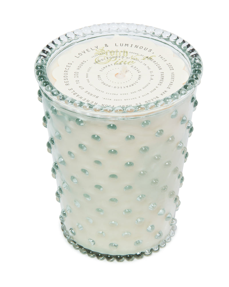A decorative Simpatico NO. 26 Scotch Pine hobnail glass candle with a labeled lid, isolated on a white background. The container features raised dots and a frosted finish.