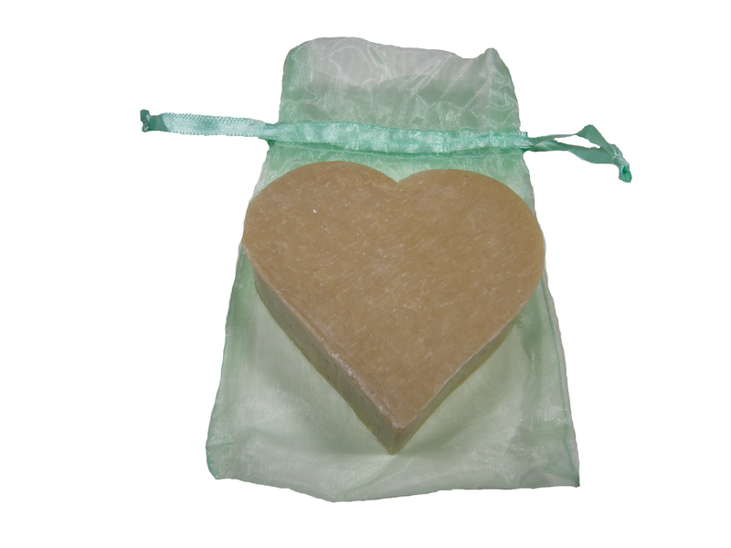 A Massalia Heart Soap of Marseille in Vetiver resting in a translucent green organza drawstring bag, isolated on a white background. Made by Made in Provence.