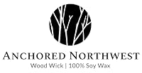 Anchored Northwest logo featuring a black circle with white tree branches. Below the circle, the text reads, "Anchored Northwest" and "Wood Wick | 100% Soy Wax".