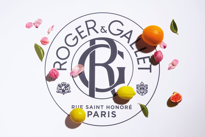 Logo of Roger & Gallet Paris on a white background surrounded by citrus fruits, pink petals, figs, and green leaves.