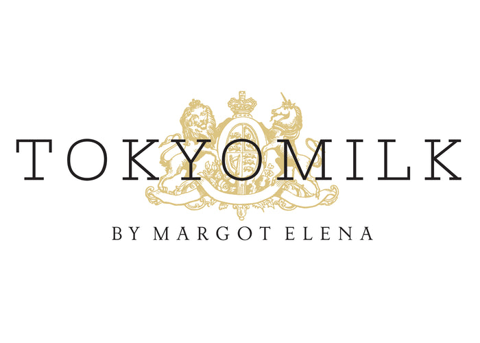Tokyomilk by Margot Elena logo featuring elegant text with gold decorative elements, including a detailed crest and two lions.