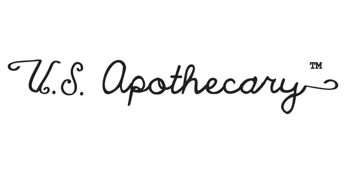 Text reading "U.S. Apothecary" in elegant, cursive font with a trademark symbol. The text is black, set against a white background.
