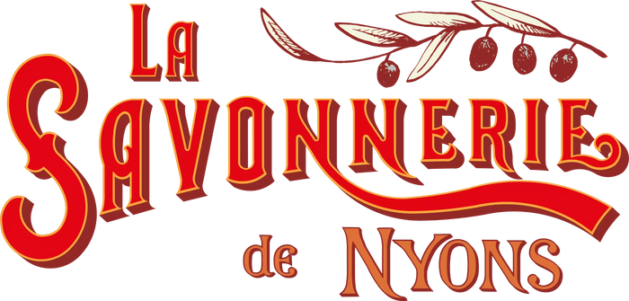 Text reading "La Savonnerie de Nyons" in red and yellow, styled in a vintage font. Olive branch with leaves and olives appears above "Nyons.