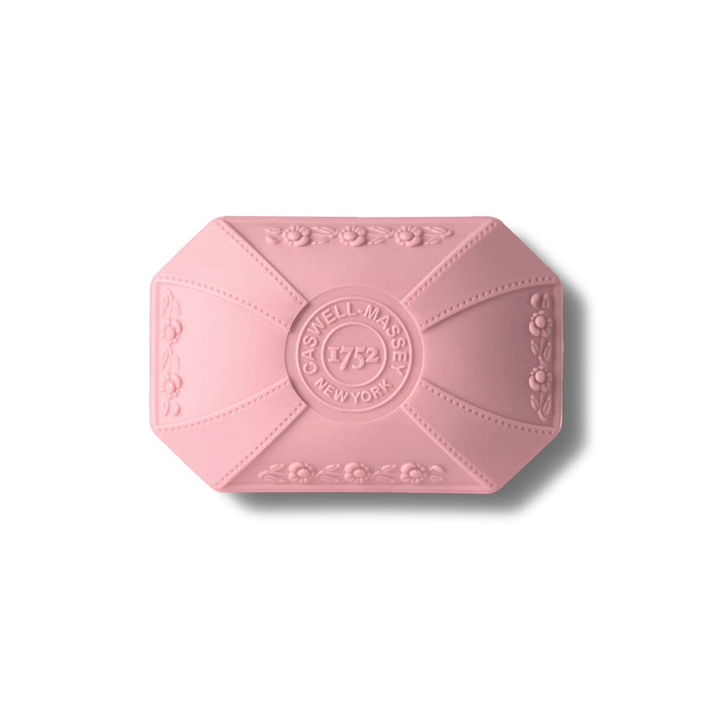 A pink, octagonal soap bar with embossed floral designs and the text "Caswell Massey Rose Luxury Bar Soap 100g" displayed on a plain, white background.