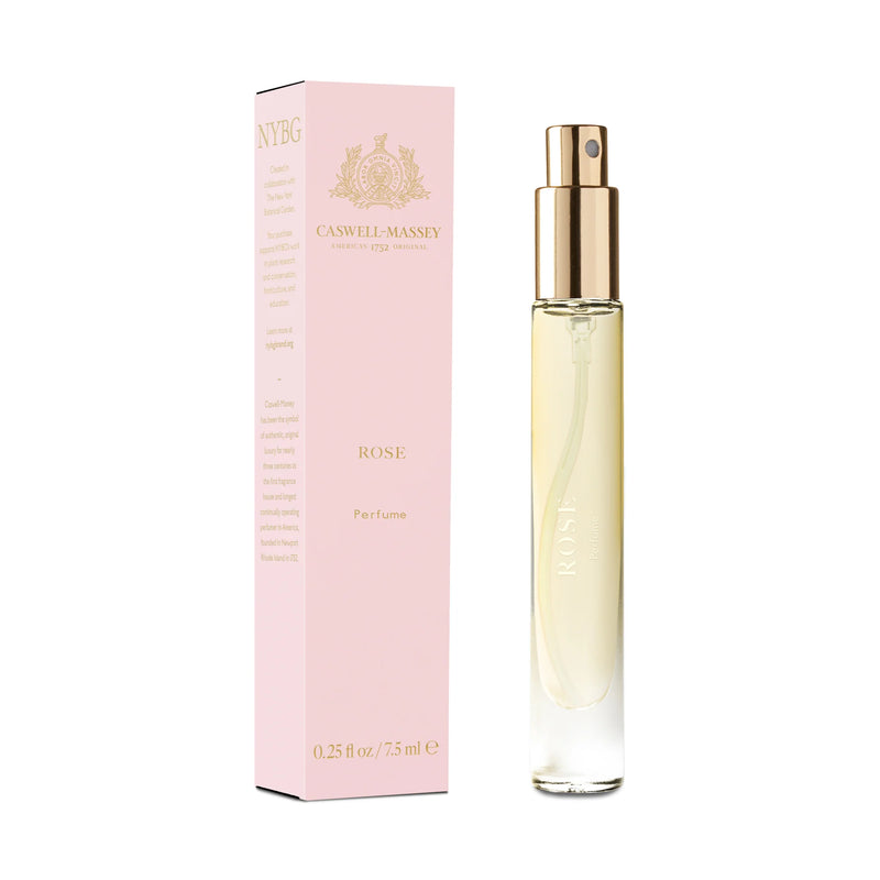 A slender, transparent perfume bottle with a gold spray nozzle, labeled "Caswell Massey Rose Perfume - 7ml" with an accompanying pale pink box featuring elegant gold text, positioned on a white background.