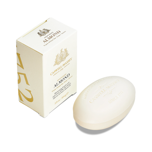 A box of Caswell Massey Almond Bar Soap stands upright beside an oval bar, both in elegant gold and cream packaging. This triple-milled soap creates a moisturizing lather and features classic Caswell Massey branding.