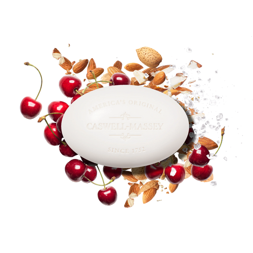 A white oval Caswell Massey Almond Bar Soap is surrounded by fresh cherries, almonds, almond shells, and sea salt on a white background, highlighting the moisturizing lather of this triple-milled soap.