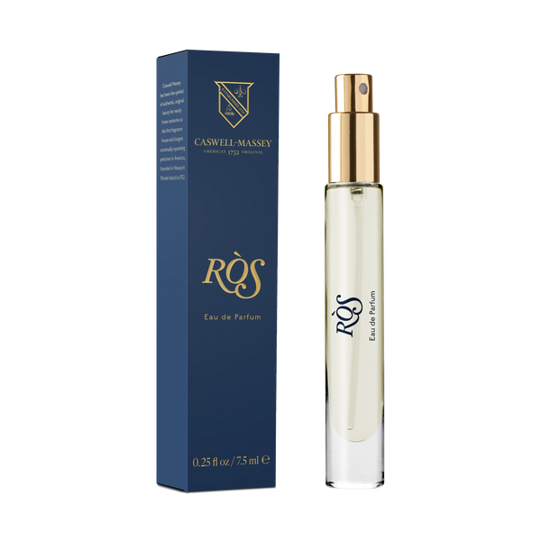 A blue and gold Caswell-Massey Ròs Eau de Parfum box stands beside a clear spray bottle with a gold lid and the same label, both on a plain white background.