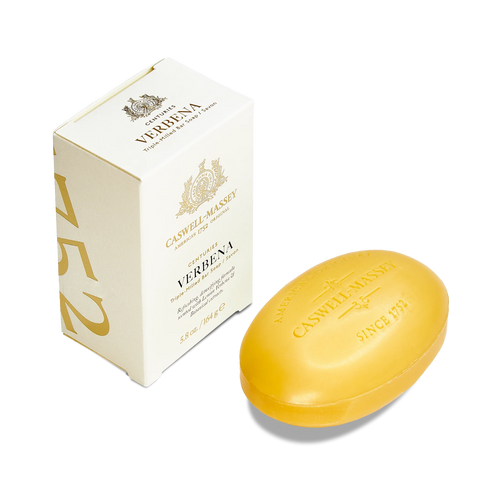 A yellow oval Caswell-Massey Verbena Bar Soap with plant-based glycerin sits beside its cream-colored box, adorned with gold text and decorative accents.