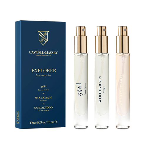 Three Caswell Massey Sandalwood Explorer Discovery Set perfume spray bottles—labeled 2571, Heritage Woodgrain Sandalwood Eau de Parfum, and Sandalwood—stand by a blue box with gold and white accents.