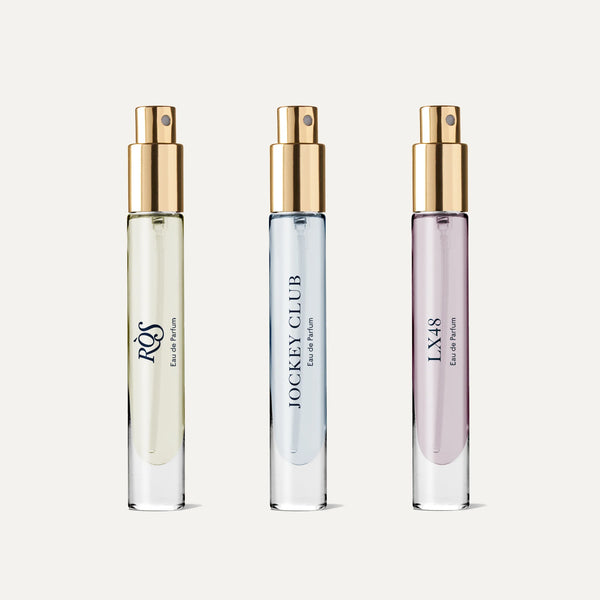 The Caswell~Massey Iconic Discovery Set displays three glass perfume bottles with gold spray tops, featuring RÒS, JOCKEY CLUB, and LX48 eau de parfum—each a unique scent for men—by Caswell-Massey.