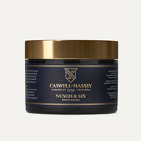 A black and gold jar of Caswell Massey Number Six Shave Cream with a gold lid, showing the brand’s logo and product details on the label of this hydrating shave cream.
