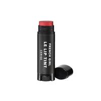 A tube of FRENCH GIRL - Tinted Lip Balm | Cerise stands upright with the cap off, showcasing the hydrating vegan formula. The sleek black tube with white text is set against a clean white background.