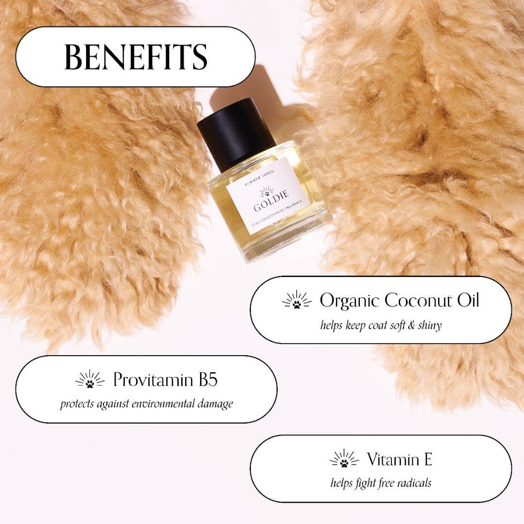 A bottle of Goldie Dog Fragrance-Summer Tonic by Goldie rests on soft, light brown fur, with text bubbles showcasing organic coconut oil, provitamin B5, and vitamin E for a soft, shiny coat—ideal for pups who love natural dog perfume.