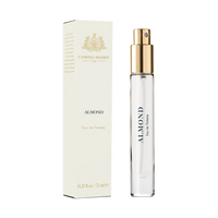 The Caswell Massey Almond Eau de Toilette (7.5 ml) comes in a clear glass bottle with a gold spray top, labeled and displayed next to its cream-colored, gold-accented box, offering a refined cherry-scented fragrance experience.