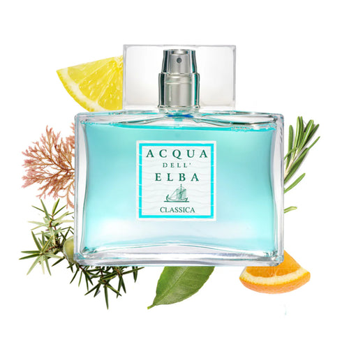 A bottle of Acqua dell'Elba Classica Uomo Eau de Parfum 50ml, an enchanting Mediterranean fragrance by Acqua dell'Elba, rests amidst its key ingredients: a slice of lemon, an orange slice, and green herbs. The light blue eau de parfum with its transparent cap features a sailboat design, evoking hints of marine algae in every spritz.