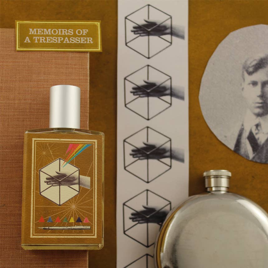 A flat lay image featuring a perfume bottle labeled "Imaginary Authors Memoirs of Trespasser - Large Size," an Adventure scent infused with Madagascar Vanilla, a small rectangular booklet, a strip of illustrations of a hand inside a hexagon, a silver flask, and a sepia-toned photograph of a man in a suit.