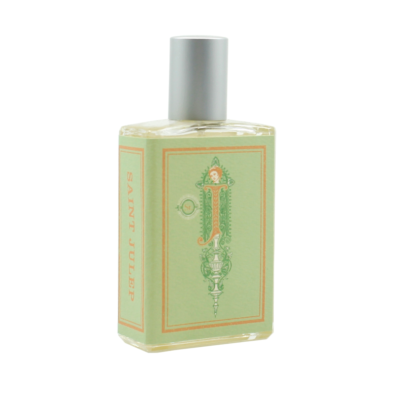 A rectangular perfume bottle with a silver cap. The label, adorned with ornate designs, is light green and features the name "Imaginary Authors Saint Julep - Large Size" printed in orange down the side. Evoking Southern charm, it also includes sweet mint accents among stylized decorative elements.