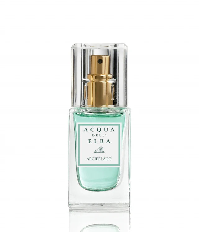 The Acqua dell'Elba Arcipelago Donna Eau de Parfum Travel Size 15ml features a clear glass bottle adorned with a gold spray nozzle, exuding elegance. The fragrance carries the name "Acqua dell'Elba Arcipelago," suggesting a citrus allure. Enveloped in a light blue hue, the scent hints at floral feminine notes, including jasmine, and is topped with a transparent square cap.