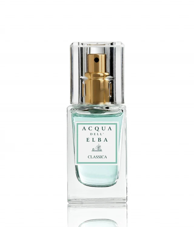 A clear glass bottle featuring a gold spray nozzle holds the light blue liquid of the Acqua dell'Elba Classic Donna Eau de Parfum Travel Size 15ml. The label displays "Acqua dell' Elba Classica" with a small boat logo beneath the text.