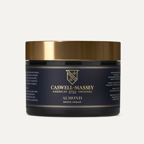 A black and gold jar of Caswell Massey Almond Shave Cream with a gold lid displays the brand name and product details on its label. This hydrating, non-foaming shaving cream is set against a plain white background.