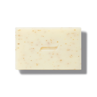 The Caswell-Massey Body Scrub Bar by Caswell Massey is a rectangular, light beige soap with brown flecks and a subtle center groove, displayed on a white background to showcase its natural exfoliating ingredients for gentle cleansing.