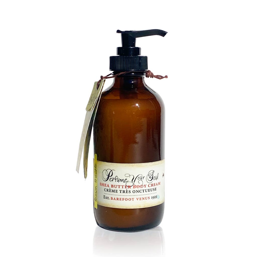 A brown glass pump bottle labeled "Barefoot Venus Lemon Freckle Body Cream," a luxurious handmade body cream by Barefoot Venus, with a tag tied around the neck.