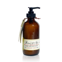 A brown glass pump bottle labeled "Barefoot Venus Lemon Freckle Body Cream," a luxurious handmade body cream by Barefoot Venus, with a tag tied around the neck.