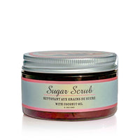 A container of handmade, cruelty-free scrub with coconut oil. The jar has a metallic screw-on lid and a label that reads, "Barefoot Venus Coconut Kiss Sugar Body Scrub." The product has a volume of 3.1 oz/90g. The paraben-free, sulfate-free packaging is light blue with a pink accent.