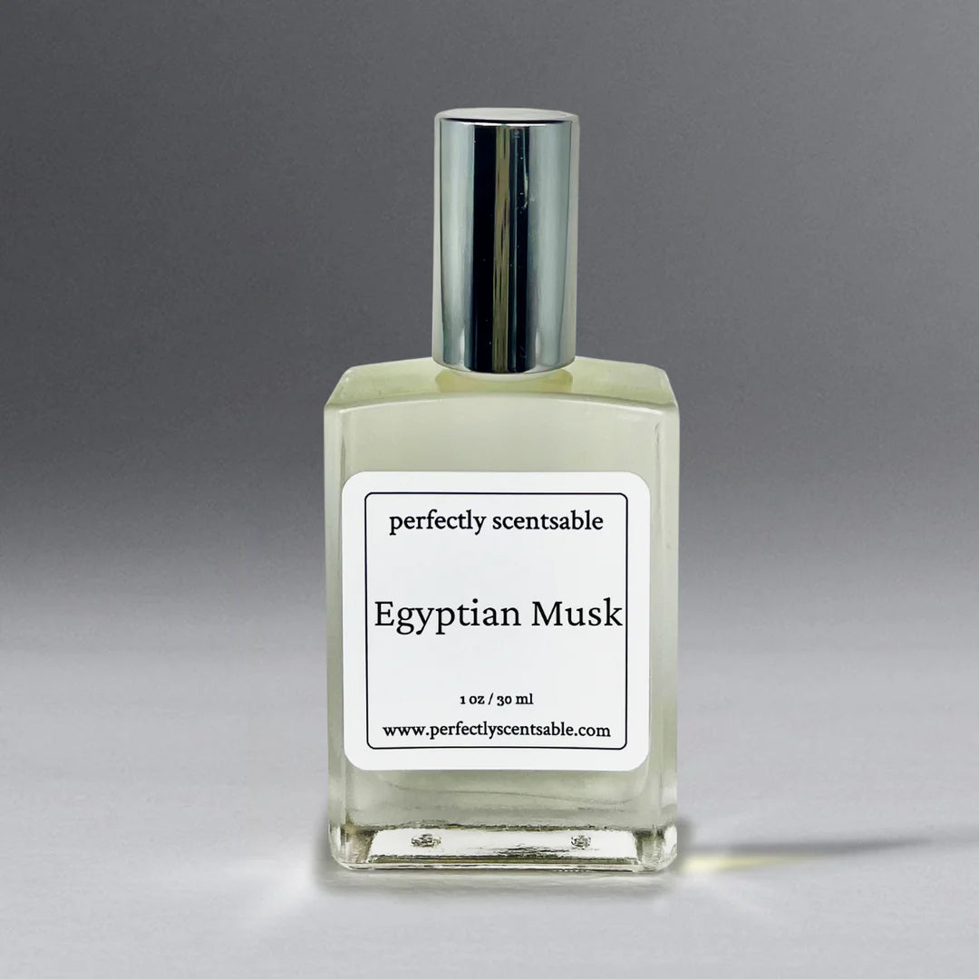 The Perfectly Scentsable Egyptian Musk Perfume Oil - 1oz comes in a square bottle with a metallic cap and features a minimalist white label adorned with black text. Known for its long-lasting fragrance, the contact information including the website "www.perfectlyscentsable.com" is printed at the bottom of the label.