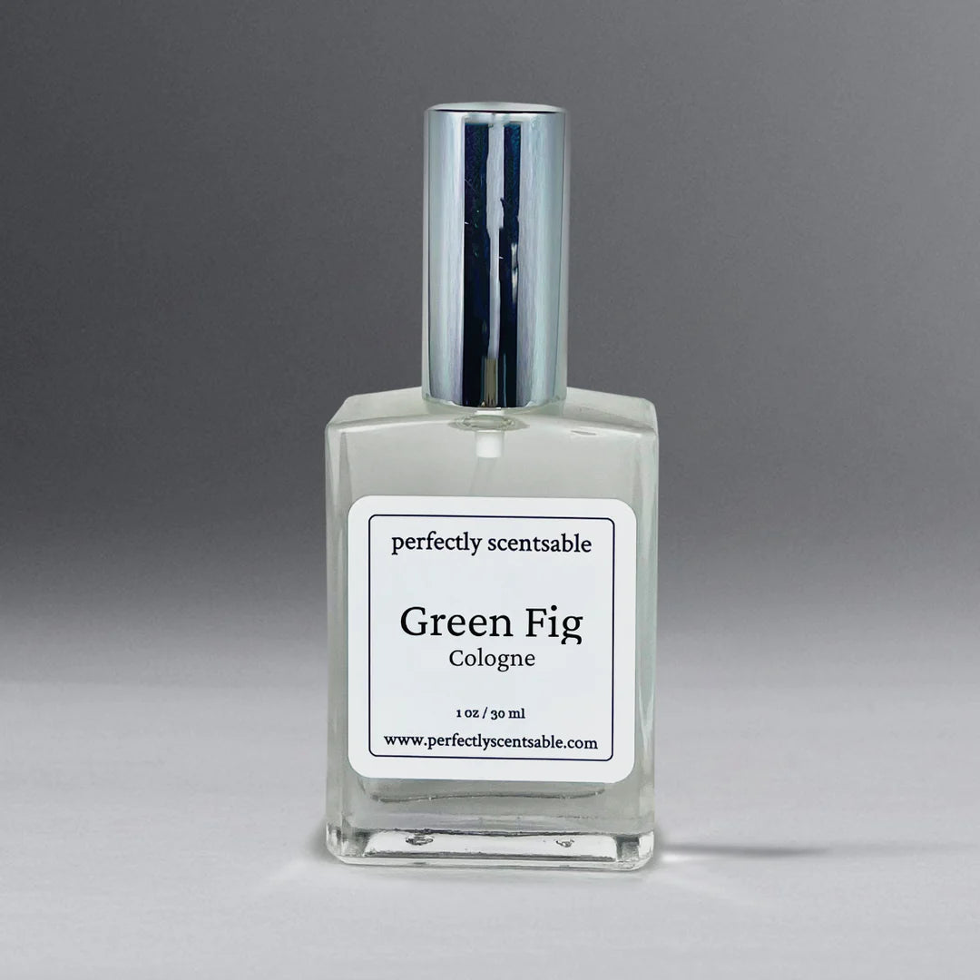 A clear glass bottle of Perfectly Scentsable Green Fig Perfume Oil - 1oz Cologne from the brand "Perfectly Scentsable." The bottle, adorned with a silver cap, contains 1 oz (30 ml) of liquid. Its earthy aroma captures the essence of fig leaf against a gradient backdrop transitioning from light to dark grey.