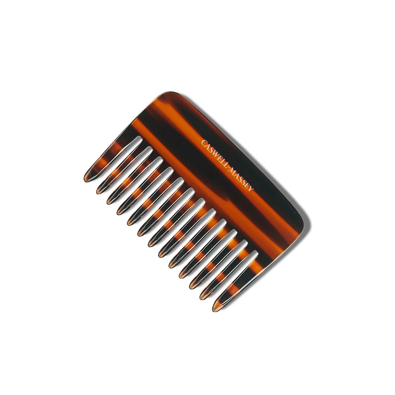 A Caswell Massey cellulose acetate tortoiseshell wide-toothed comb isolated on a white background, with "cali's hair care" written in white script along the spine.