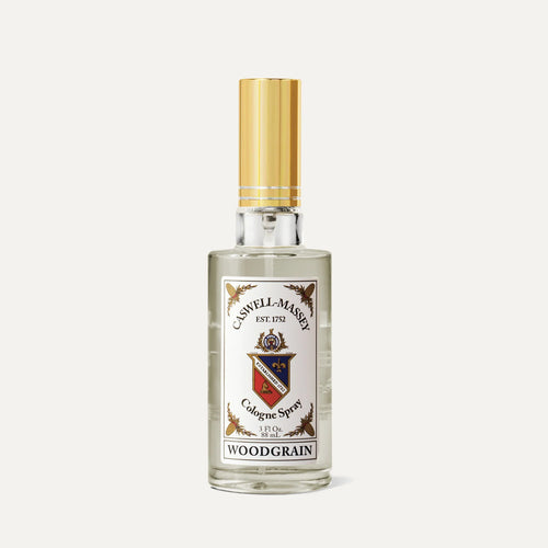 A clear glass bottle of Caswell Massey Woodgrain Sandalwood Cologne features a gold cap and decorative label—an elegant presentation for this classic sandalwood scent from Caswell Massey.