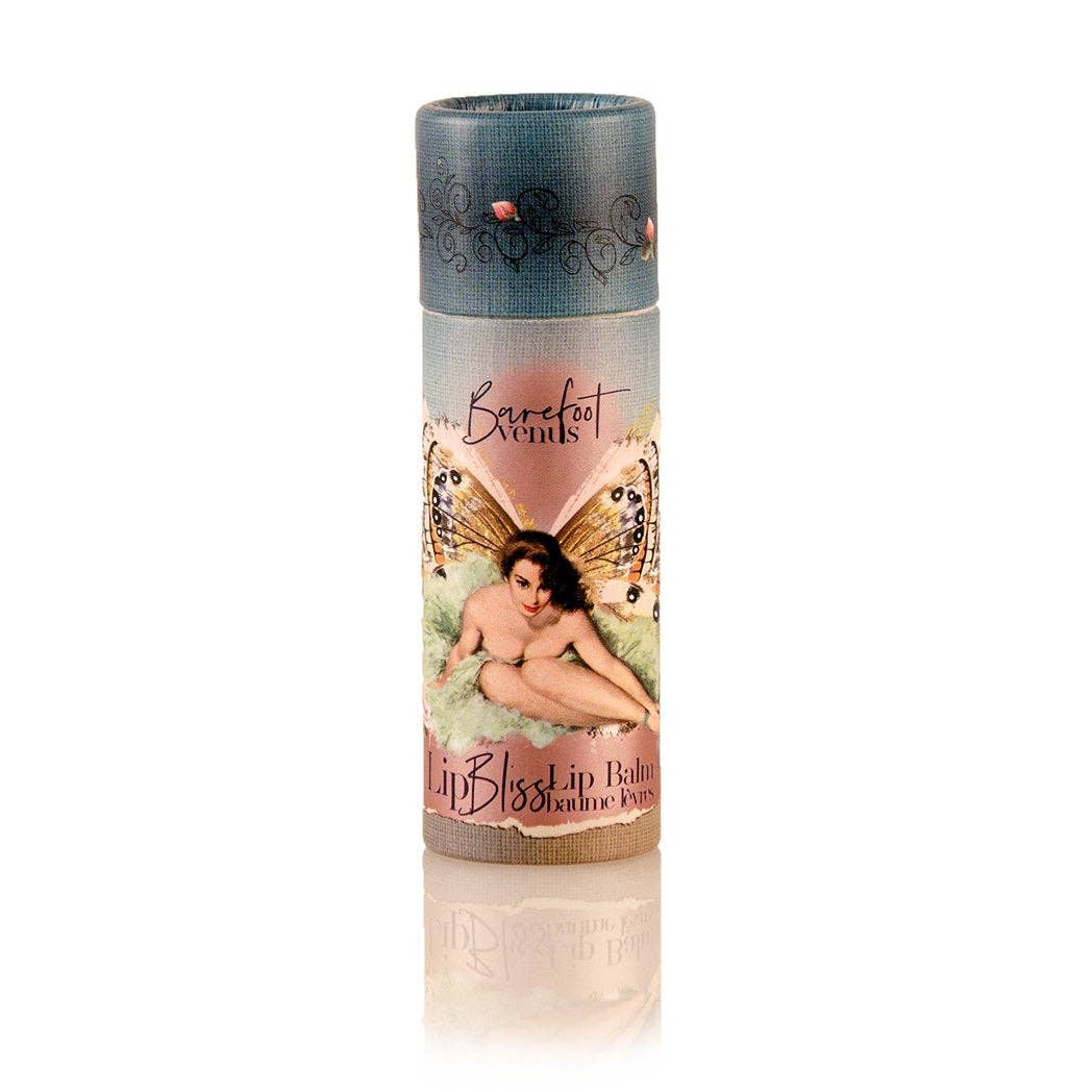 The Barefoot Venus The Vanilla Effect Lip Balm comes in a cylindrical tube adorned with a vintage-style label featuring a winged woman and floral designs on the cap, along with text branding. Infused with moisturizing Shea Butter, it's ideal for keeping your lips soft and nourished.