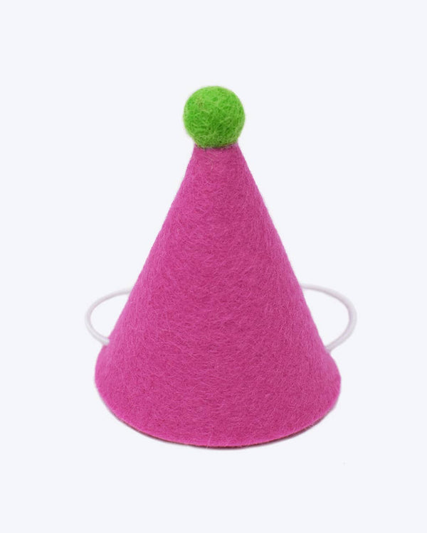 The MODERNBEAST Wool Pet PAWTY HAT is a small pink wool party hat with a green pom-pom and adjustable white elastic, perfect as a cute dog birthday hat.