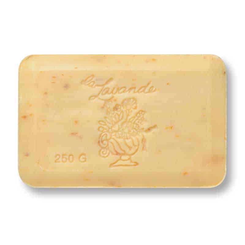 The La Lavande Grapefruit Peel French Bath Soap is a rectangular beige bar with small brown flecks, embossed with "la Lavande," a floral vase, and "250 G" on the bottom left corner.