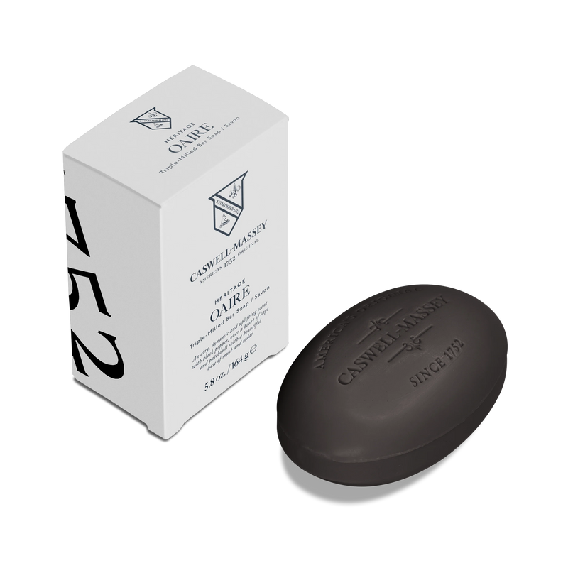 A black oval Caswell-Massey Oaire Bar Soap rests next to its white rectangular box, featuring black lettering and the number 752 on the side.