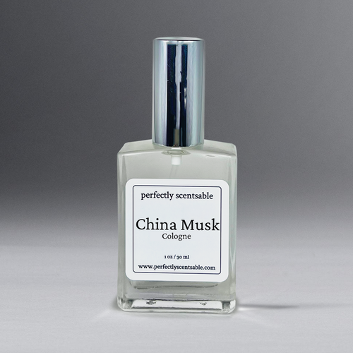 A square glass bottle of cologne labeled "Perfectly Scentsable China Musk Perfume Oil - 1oz Cologne Spray" exudes a timeless aroma. The bottle, capped with metallic elegance, holds 1 oz/30 ml of liquid. Visit the brand's website at www.perfectlyscentsable.com for this versatile scent.