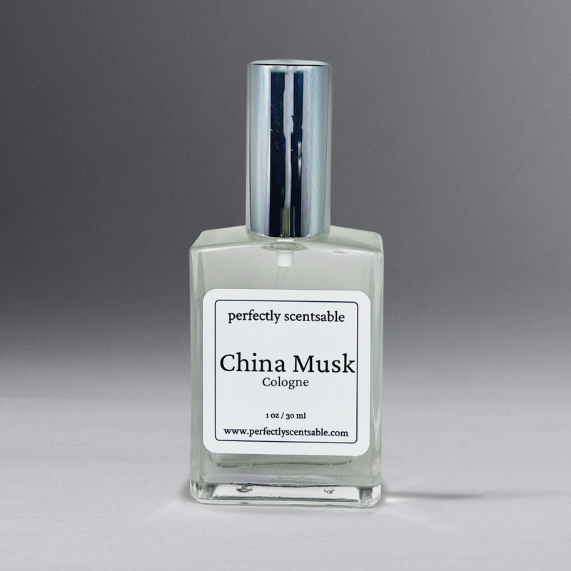 A square glass bottle of cologne labeled "Perfectly Scentsable China Musk Perfume Oil - 1oz Cologne Spray" exudes a timeless aroma. The bottle, capped with metallic elegance, holds 1 oz/30 ml of liquid. Visit the brand's website at www.perfectlyscentsable.com for this versatile scent.