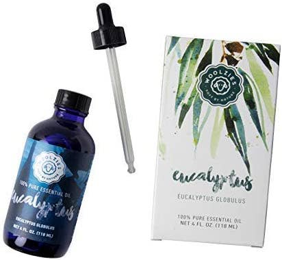 A blue Woolzies Eucalyptus Essential Oil bottle with dropper comes in a box with watercolor eucalyptus leaves and "eucalyptus" in cursive—ideal for supporting respiratory health.