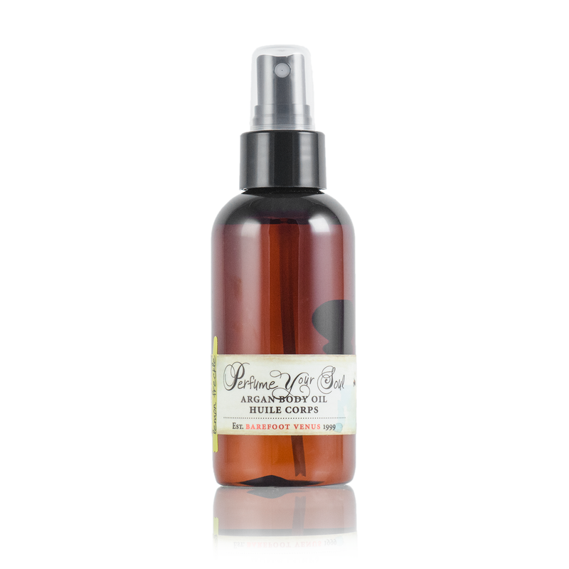 A brown spray bottle labeled "Barefoot Venus Lemon Freckle Argan Body Oil" offers intense hydration with its plant-based formula. It features a white and silver cap, adorned with the text "Perfume Your Soul" and "Barefoot Venus." The simple elegance of its design stands out against the white background.