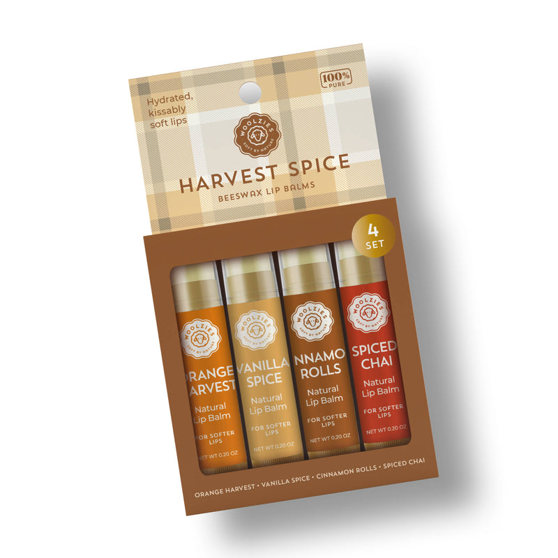 Packaging for a set of four Woolzies Harvest Spice lip balms, enhanced with essential oil, with flavors including orange spice, vanilla spice, cinnamon rolls, and spiced chai.