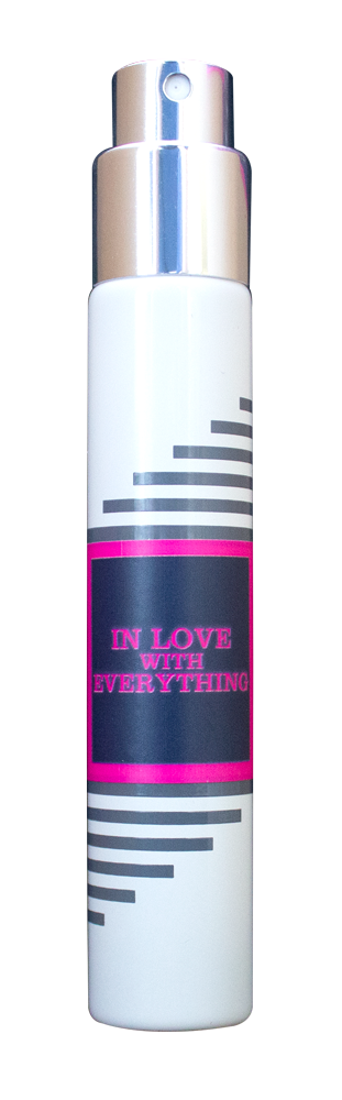 A white cylindrical spray bottle features a metallic nozzle and cap, adorned with black and grey striped accents. It showcases a pink-bordered black label reading "In Love With Everything" from Imaginary Authors. This travel-size fragrance delivers an energizing scent perfect for everyone, making it the ultimate gender-neutral perfume.