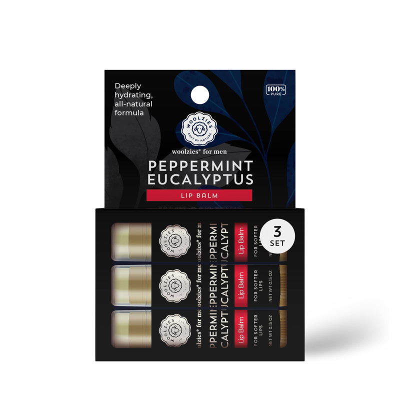 A box of "Woolzies Peppermint - Eucalyptus Lip Balm For Men," featuring three lip balm tubes. The packaging is dark with blue botanical designs and lists benefits like vegan.