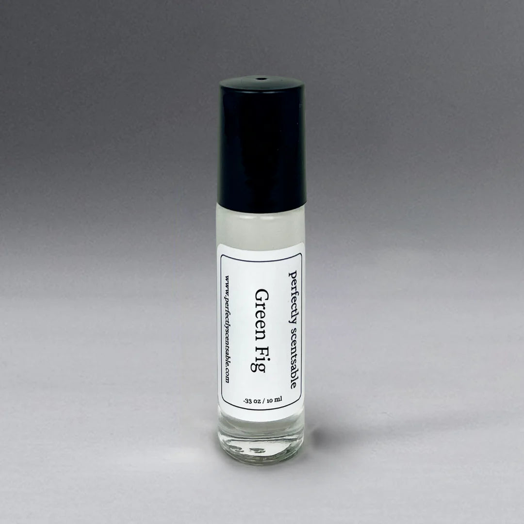 A 10 ml (0.33 oz) glass bottle with a black cap featuring the "Perfectly Scentsable" and "Green Fig" labels, containing a clear liquid. The information is printed in black on a white label against a plain gradient background transitioning from gray to white.