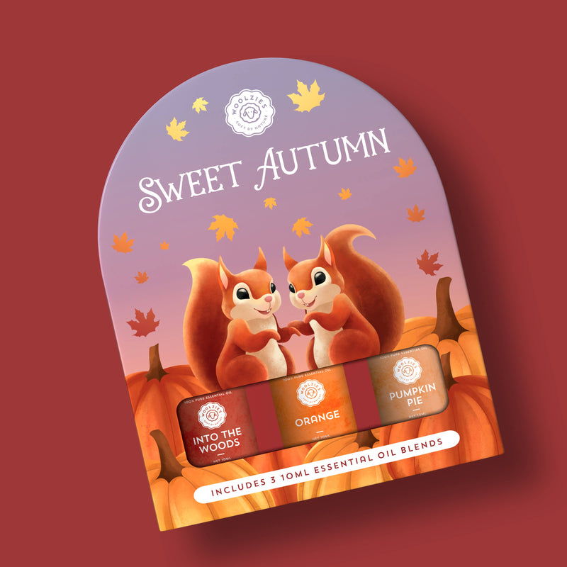 The Woolzies Sweet Autumn Collection package by Woolzies features two smiling squirrels among pumpkins and leaves, and contains three essential oils: Into the Woods, Orange, and Pumpkin Pie.