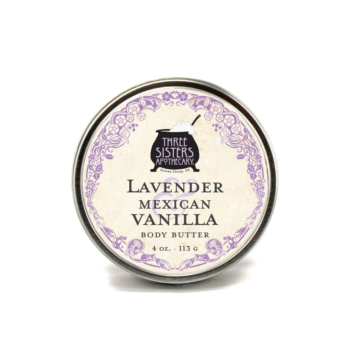 A round tin of Three Sisters Apothecary Lavender & Mexican Vanilla Body Butter, 4 oz (113 g), features a decorative purple border and vintage font—ideal for natural skin hydration.