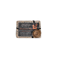 The Three Sisters Apothecary Intensions Bar Soap - Manifestation Magic is a rectangular soap bar from "Three Sisters Apothecary." The packaging features elaborate designs, including a small gold seal and text. Infused with an ancient manifestation formula, the natural beige soap has a dark, ornate label that hints at ancestral wisdom.