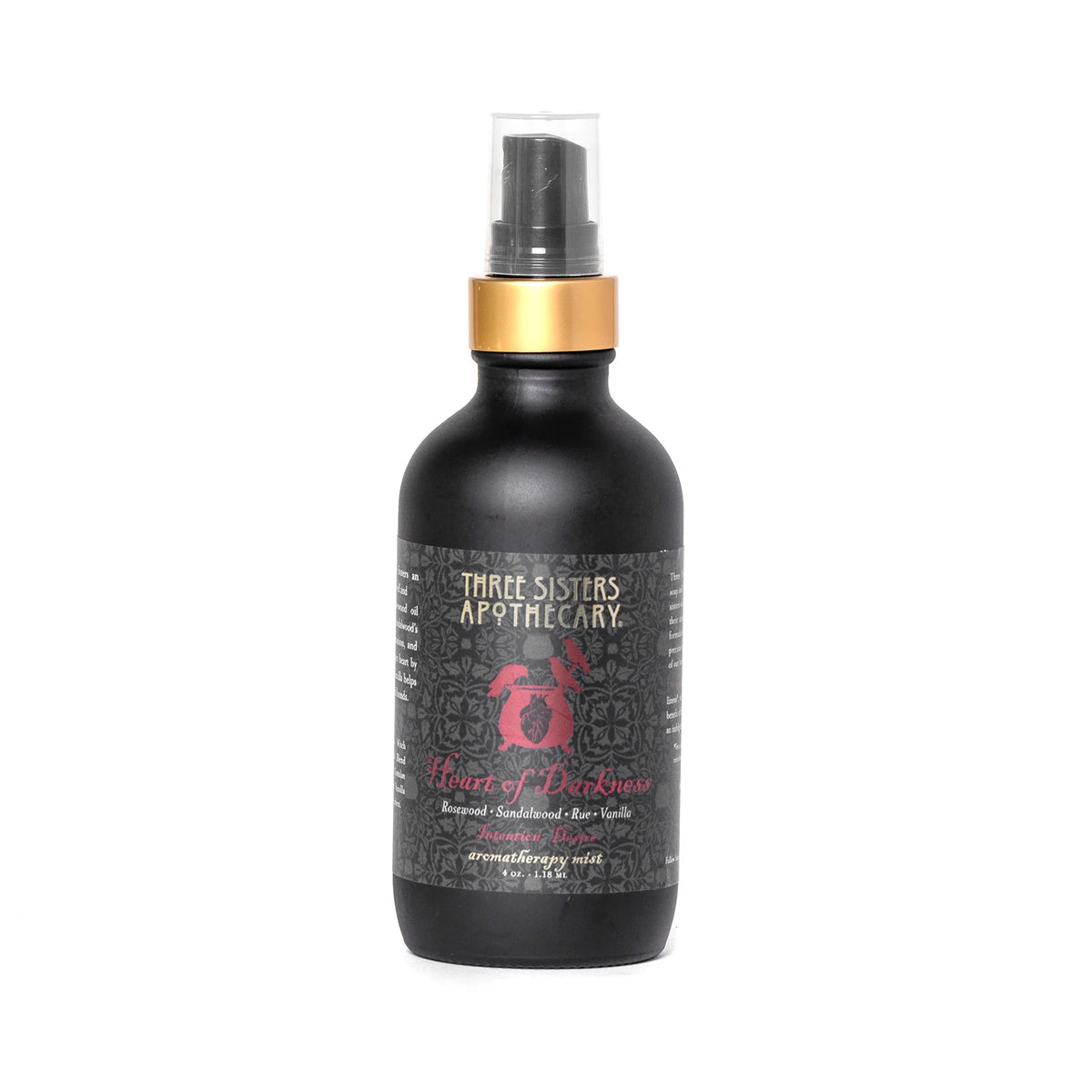 A black bottle of "Three Sisters Apothecary Intentions Aromatherapy Mist - Heart of Darkness" features a gold cap and a spray nozzle. The label includes a red rose graphic and decorative designs with text details about the compassionate essential oils in the Heart of Darkness blend.